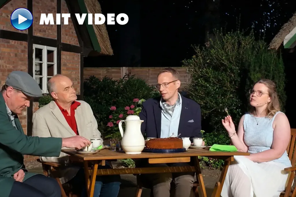 Four adults sit around a wooden outdoor table at night, sharing tea and cake in a garden setting, with a MIT VIDEO watermark in the corner.